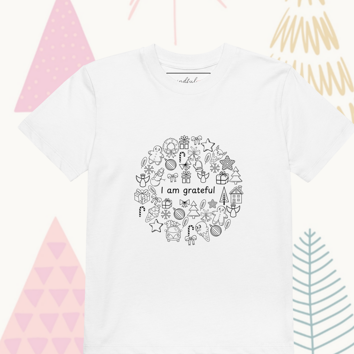 This kids' Gratitude Doodles Color-in Tee from byKath.com is made from organic cotton and showcases a circular holiday-themed design with icons such as gifts, stars, and candy canes. The center text reads "I am grateful," set against pastel-colored abstract trees. It's the perfect choice for eco-conscious holiday cheer.