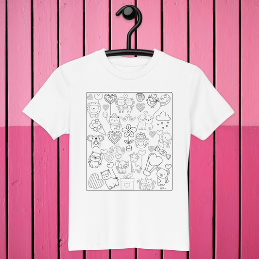 Introducing the Heart Doodles Color-in Tee by byKath.com: a white kids' t-shirt showcasing a delightful black-and-white doodle design featuring animals, hearts, flowers, and whimsical shapes. Made from organic cotton for ultimate comfort and style, this charming T-shirt is displayed on a black hanger against a pink wooden plank background.